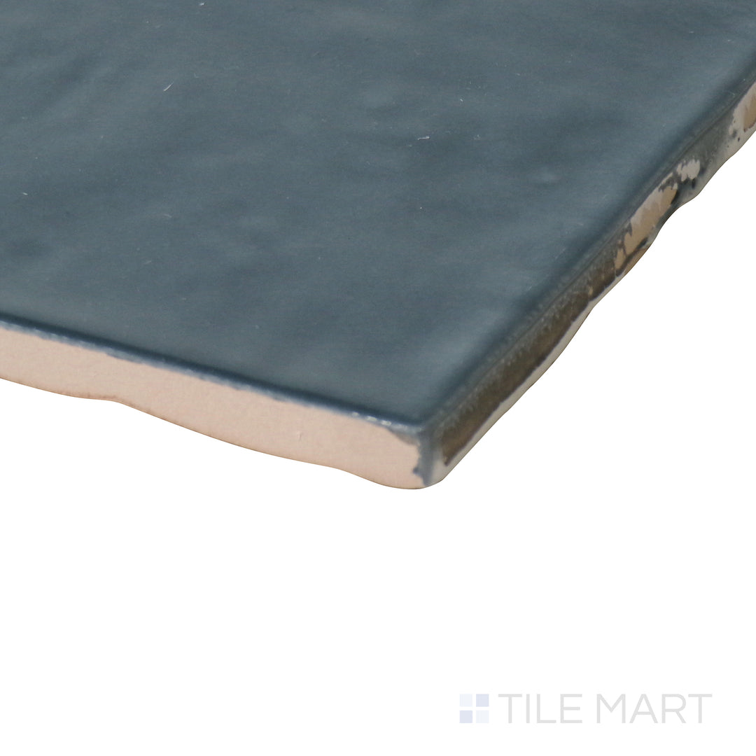 Side-angle close-up of Marin Midnight Tide 4x4 gloss glazed ceramic tile, highlighting its rich navy hue, glossy sheen, and how its edges form a smooth corner.