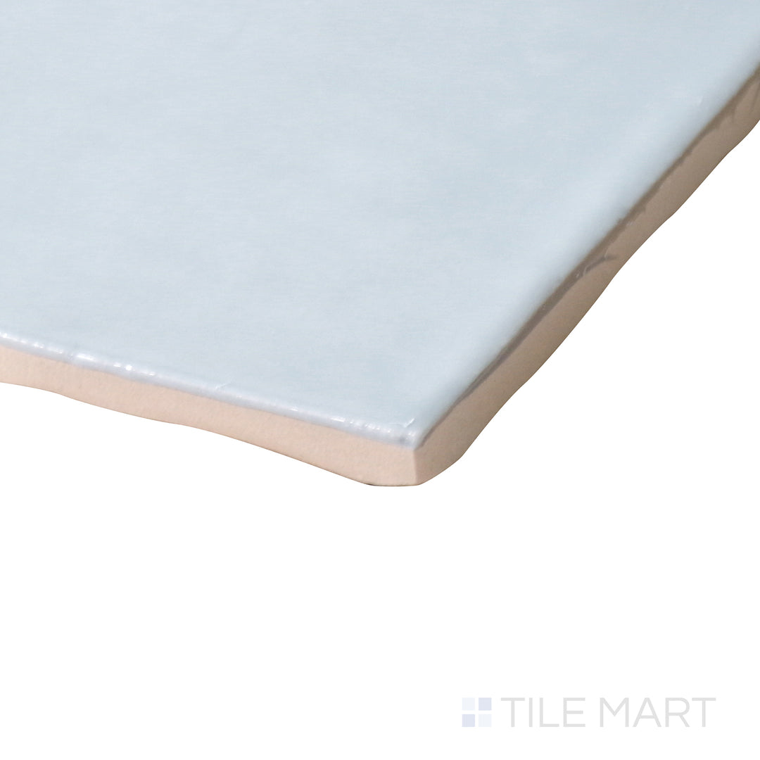 Corner-focused image of Marin Misty Blue 4x4 gloss glazed ceramic tile, emphasizing its subtle blue shade, reflective finish, and structured edge formation.