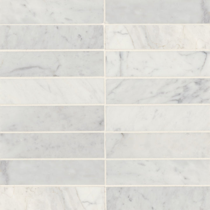 A top-down view of Monet White Carrara 2X8 Honed Marble showcases soft white hues with delicate veining, offering a timeless, luxurious aesthetic.