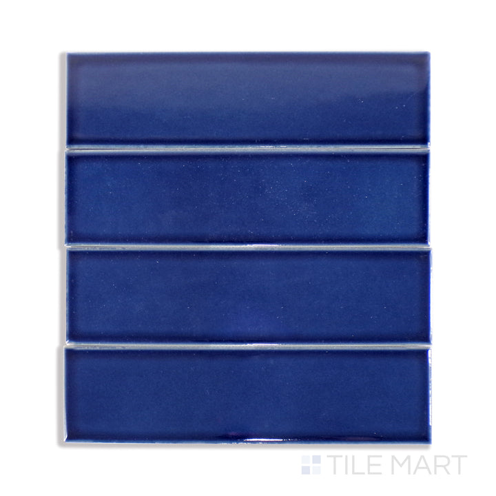 An ultra-close shot of Zenia Tide 2.5X9 Gloss Glazed Porcelain tile captures its deep blue hue and polished sheen, reminiscent of flowing ocean waves.