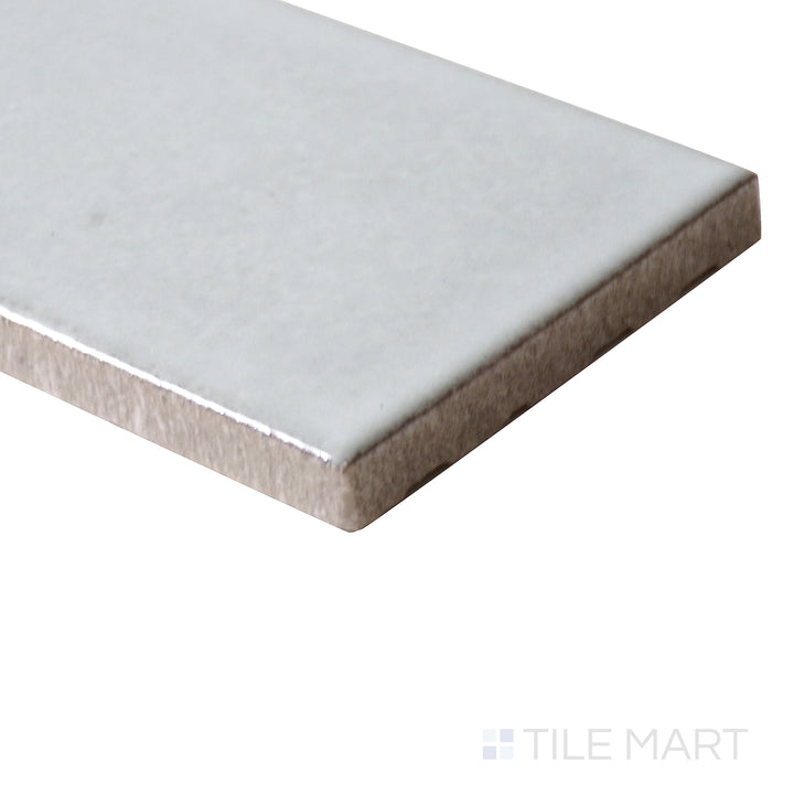 Corner-focused image of Zenia Moon 2.5x9 matte glazed porcelain tile, emphasizing its soft lunar grey color, smooth matte surface, and seamless edge transition.