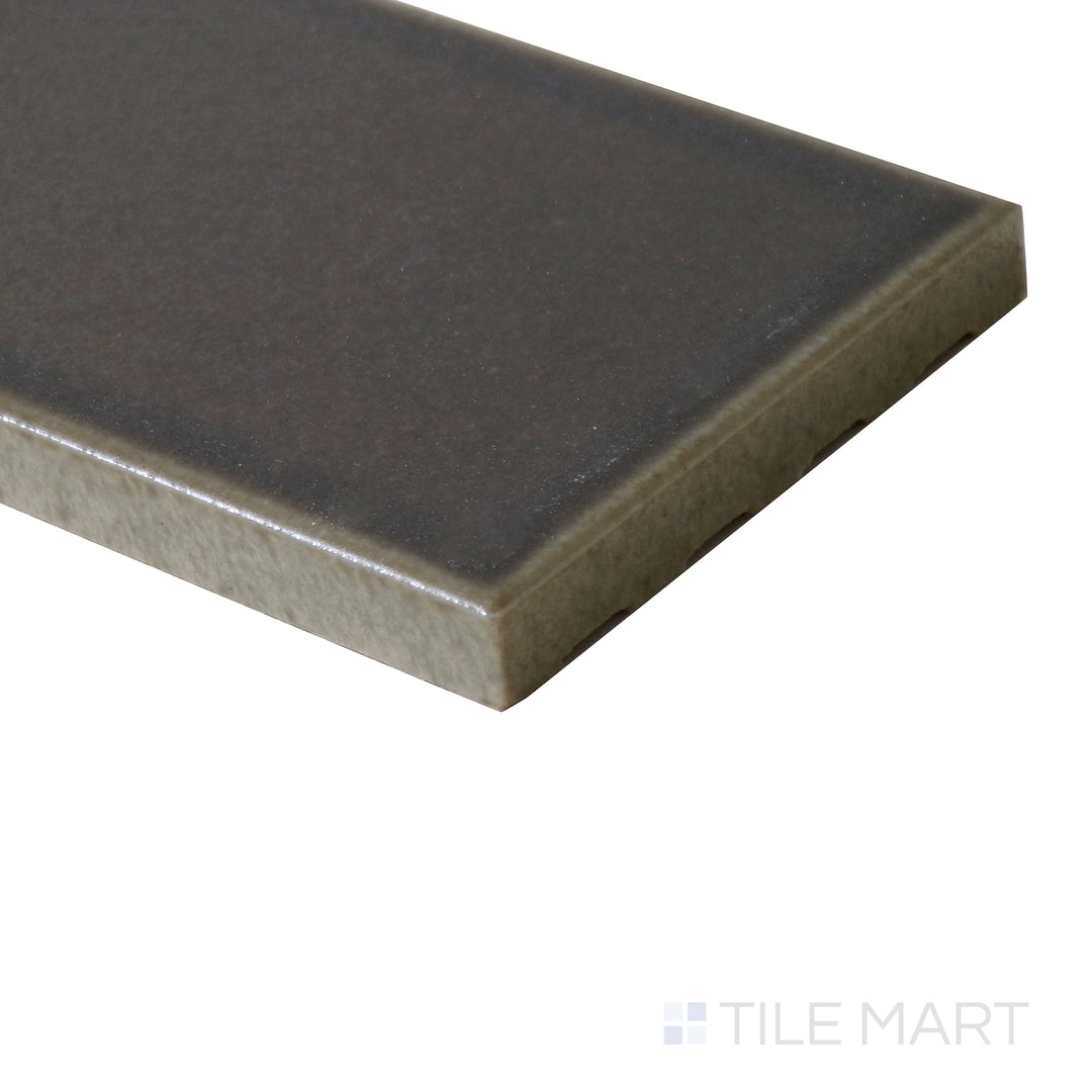 Angled view of Zenia Umbra 2.5x9 matte glazed porcelain tile, highlighting its shadowy grey-black shade, smooth matte surface, and defined edge formation.