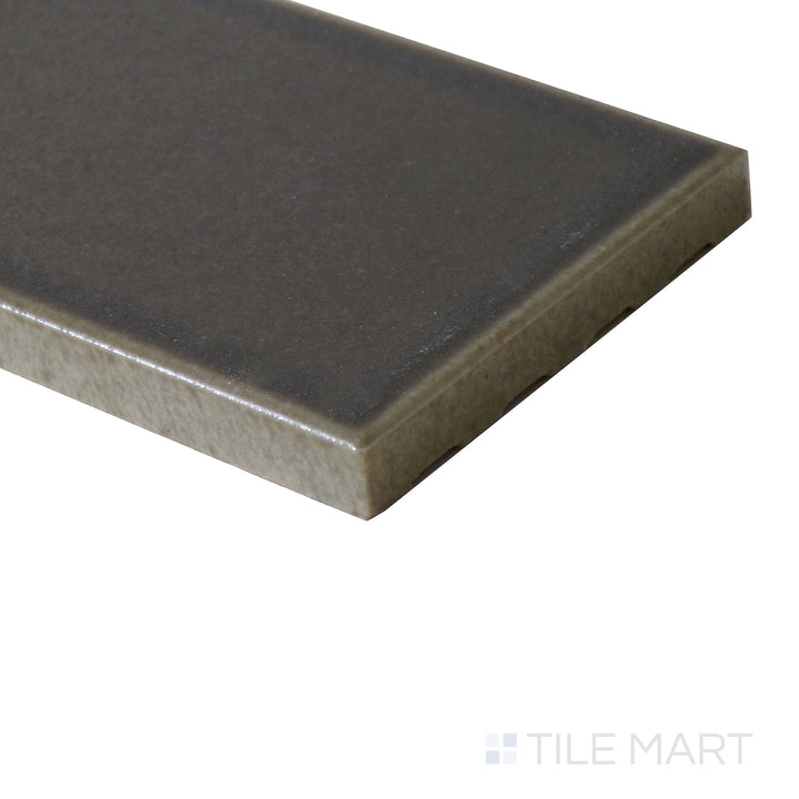 Angled view of Zenia Umbra 2.5x9 matte glazed porcelain tile, highlighting its shadowy grey-black shade, smooth matte surface, and defined edge formation.