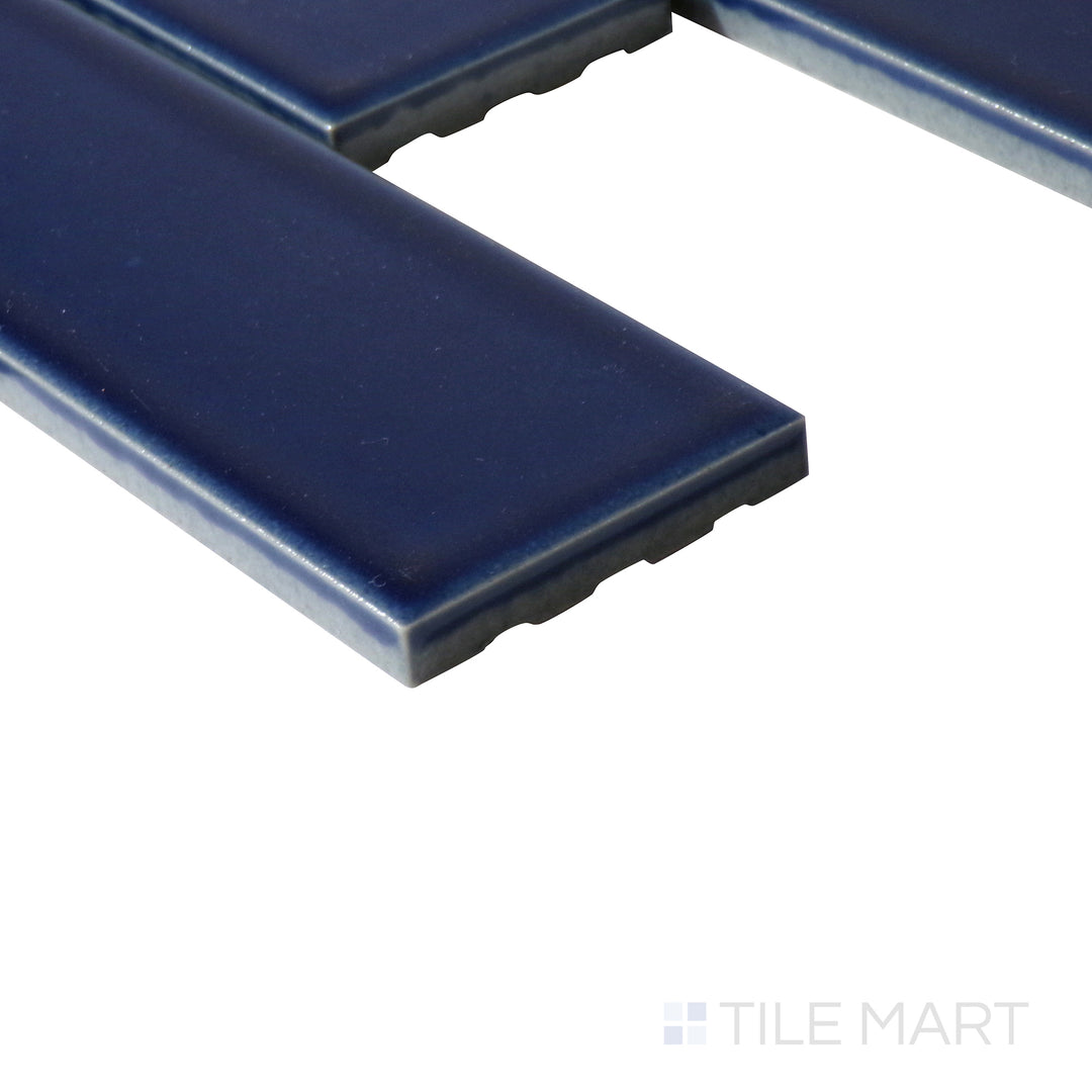 Angled perspective of Zenia Tide rectangle gloss glazed porcelain mosaic, showcasing its deep blue shade, glossy texture, and structured corner meeting point.