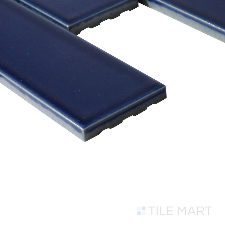 Angled perspective of Zenia Tide rectangle gloss glazed porcelain mosaic, showcasing its deep blue shade, glossy texture, and structured corner meeting point.
