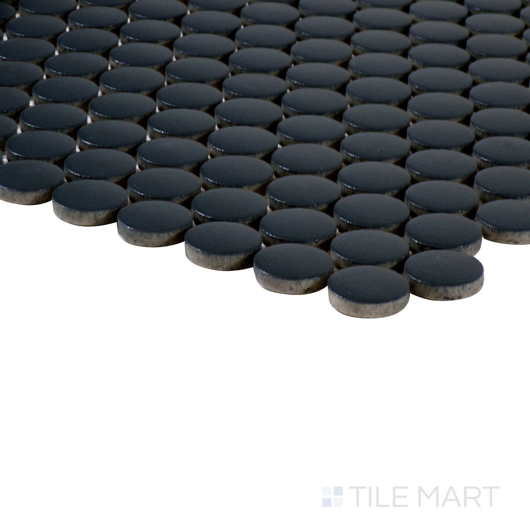Angled perspective of Marin Black Sea 3/4" penny round matte glazed porcelain mosaic, featuring its deep black shade, uniform penny layout, and finely cut edges at the corner.