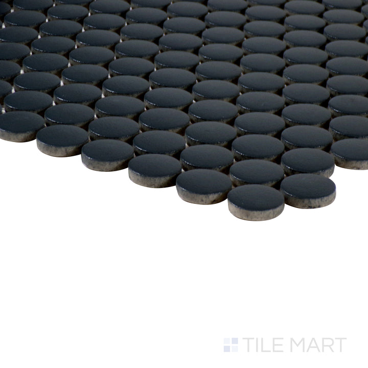 Angled perspective of Marin Black Sea 3/4" penny round matte glazed porcelain mosaic, featuring its deep black shade, uniform penny layout, and finely cut edges at the corner.