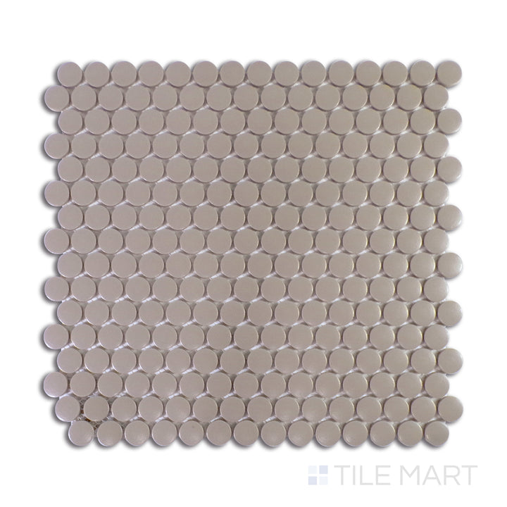 An intricate macro shot of Marin Coastal Cliff 3/4" Penny Round Matte Glazed Porcelain Mosaic captures its subtle coastal tones and non-reflective finish, perfect for serene aesthetics.