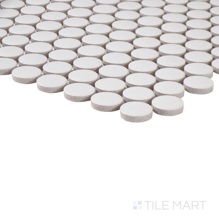 Angled view of Marin Pearl White 3/4" penny round matte glazed porcelain mosaic, showcasing its bright white hue, velvety matte surface, and structured tile arrangement.