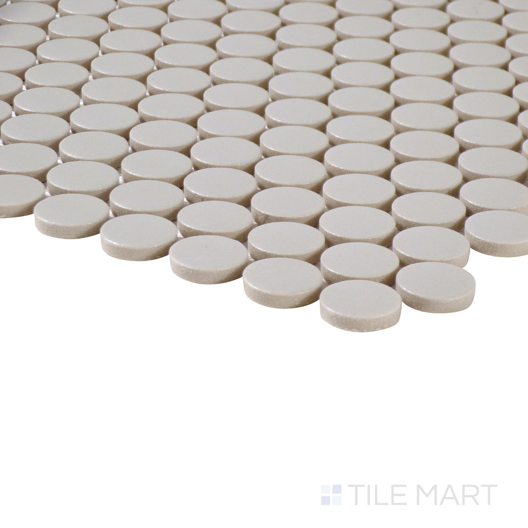 Side-angle close-up of Marin Pebble Gray 3/4" penny round matte glazed porcelain mosaic, highlighting its neutral gray shade, matte texture, and precise penny tile placement.