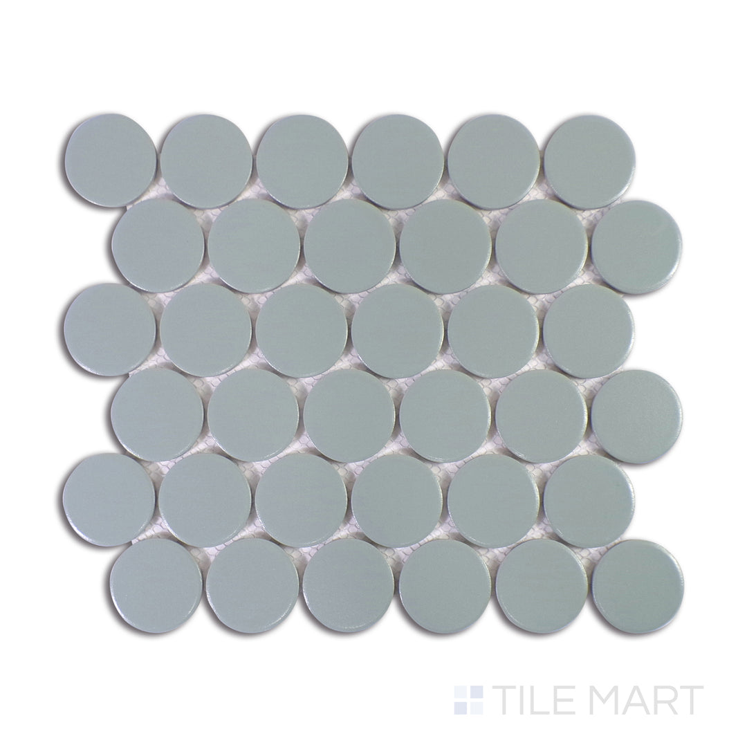 A close-up view of Marin Aloe Green 2" Penny Round Matte Glazed Porcelain Mosaic accentuates its organic green hues and muted matte finish, ideal for refreshing interiors.