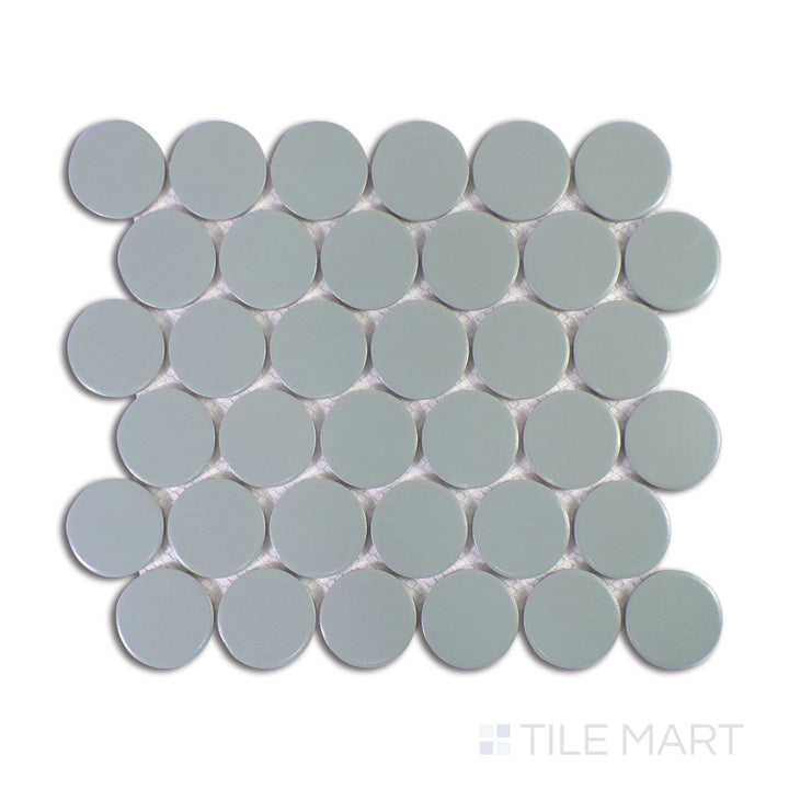 A close-up view of Marin Aloe Green 2" Penny Round Matte Glazed Porcelain Mosaic accentuates its organic green hues and muted matte finish, ideal for refreshing interiors.