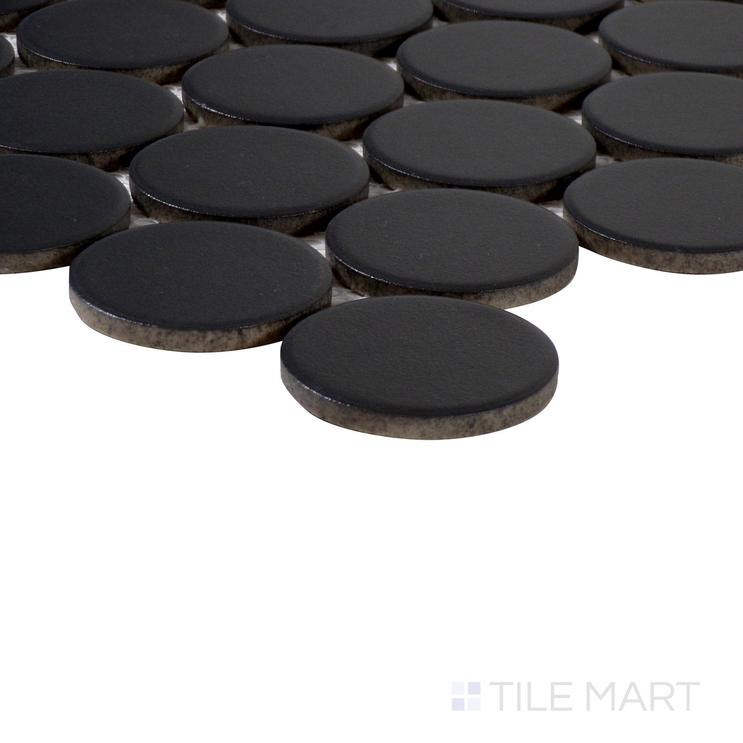 Angled perspective of Marin Black Sea 2" penny round matte glazed porcelain mosaic, featuring its bold black shade, matte surface, and seamless transition between tiles.