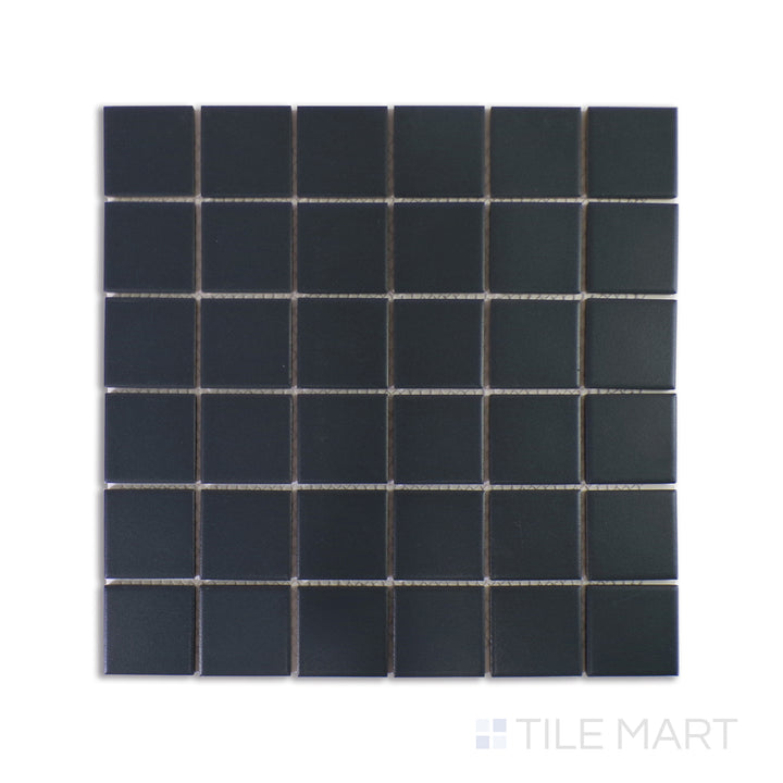A highly detailed macro shot of Marin Midnight Tide 2" Square Matte Glazed Porcelain Mosaic captures its deep blue hues with a velvety matte finish, embodying a sophisticated oceanic feel.