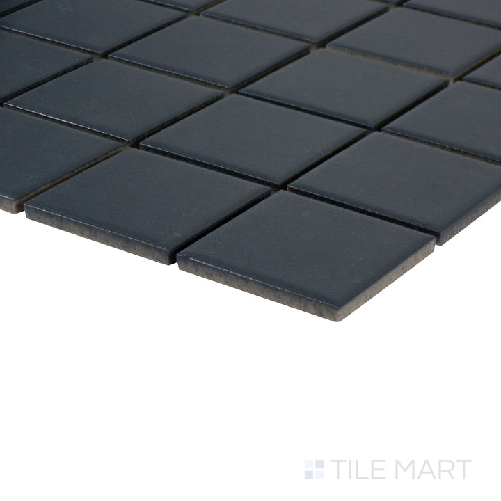 Side-angle close-up of Marin Midnight Tide 2" square matte glazed porcelain mosaic, highlighting its deep navy blue tone, smooth matte texture, and seamless corner transition.
