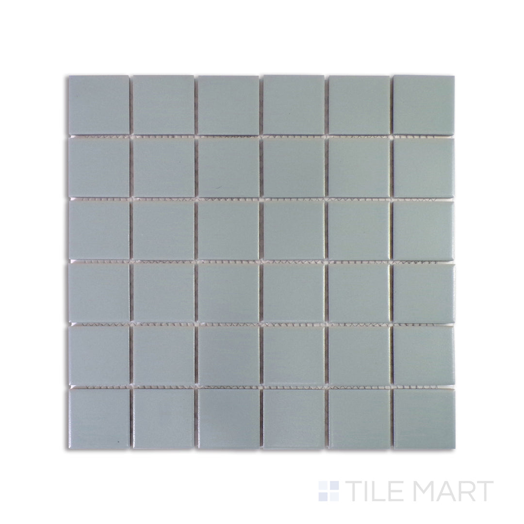 An intricate close-up of Marin Misty Blue 2" Square Matte Glazed Porcelain Mosaic highlights its muted blue tones and smooth matte surface, delivering a tranquil atmosphere.