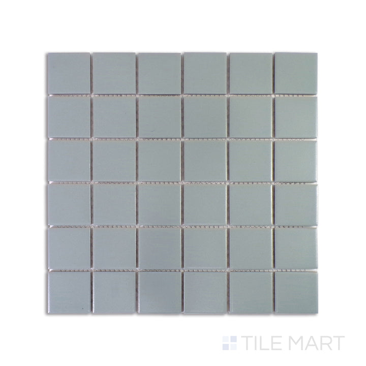 An intricate close-up of Marin Misty Blue 2" Square Matte Glazed Porcelain Mosaic highlights its muted blue tones and smooth matte surface, delivering a tranquil atmosphere.