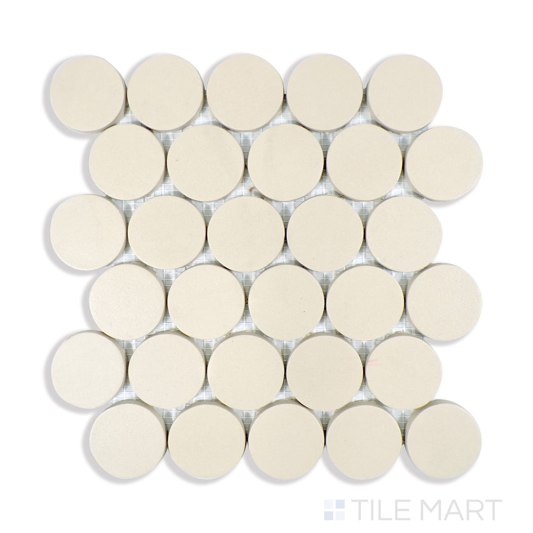 A finely detailed macro shot of Makoto Tatami Beige 2" Round Matte Porcelain Mosaic showcases its soft beige hues and smooth matte texture, ideal for natural and serene designs.