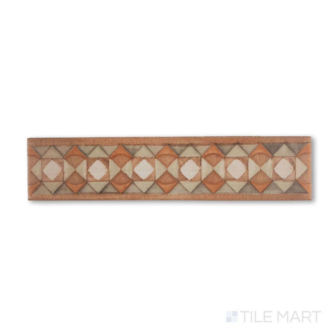 Flat-lay image of Cotto Nature Tira Volterra 3x14 gloss porcelain liner, showing an ornamental stripe pattern with hand-drawn appeal and warm, rustic coloration.
