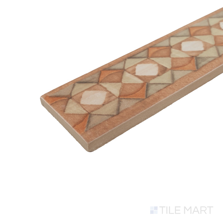 Corner close-up of Cotto Nature Tira Volterra 3x14 deco hand-painted gloss porcelain liner highlighting its smooth edge and painted detail.