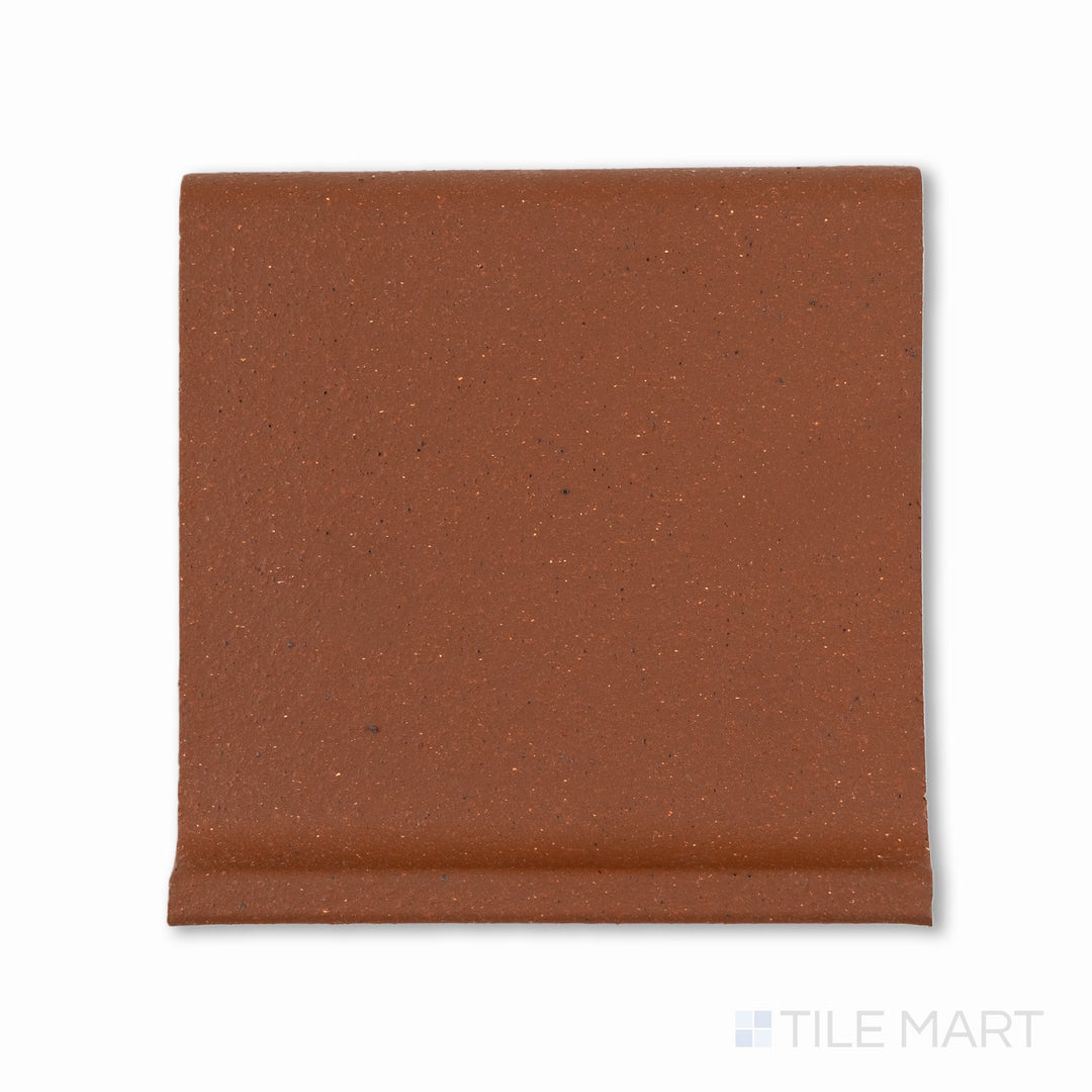 Top-down view of Metropolitan Mayflower Red 6x6 honed quarry cove base, highlighting a smooth curve transition at the base, in rich red ceramic.