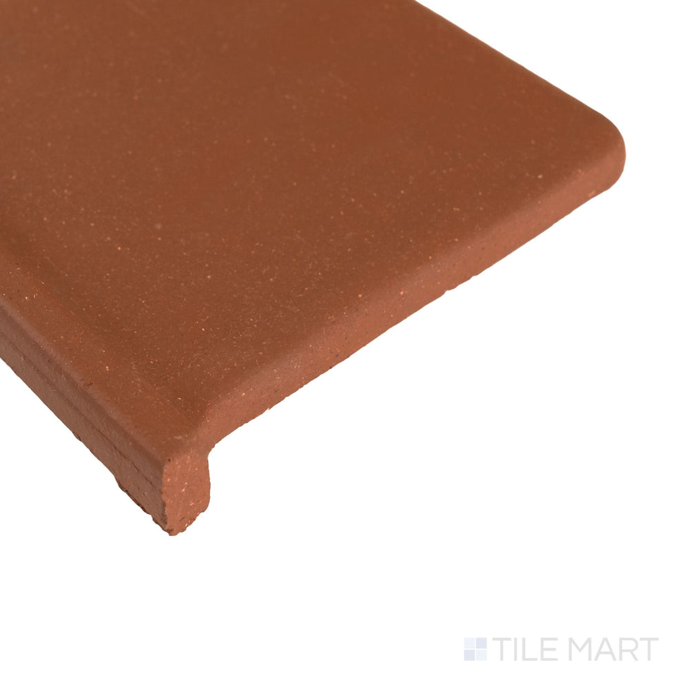 Corner detail of Metropolitan Mayflower Red 6x6 honed quarry cove base left corner showing rounded transition and matte surface.