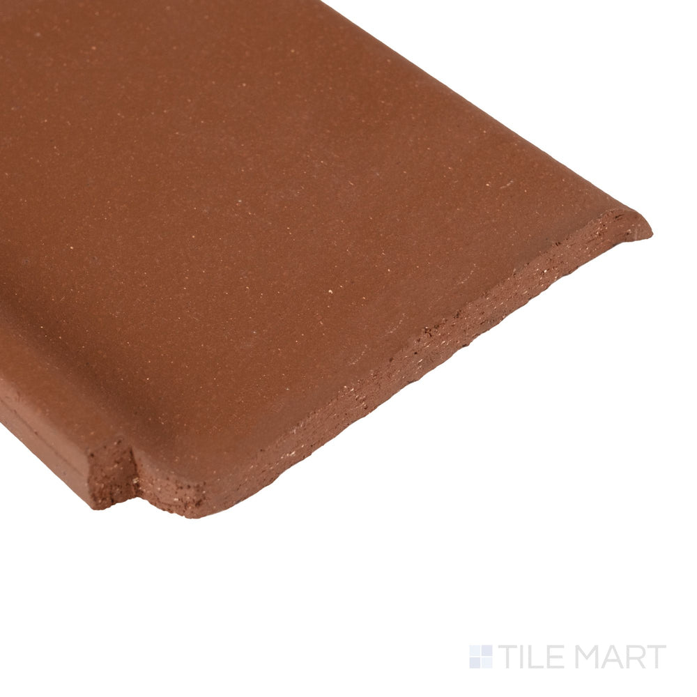 Corner close-up of Metropolitan Mayflower Red 6x6 honed quarry cove base inside corner showing curved transition and matte surface.