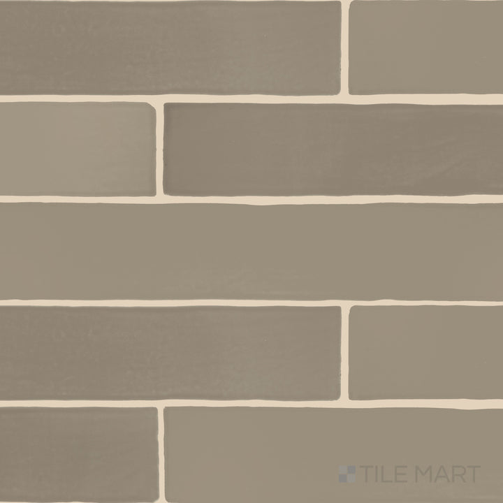 A flat-lay shot of Farrier Grullo 2.5x15 satin glazed ceramic tiles, displaying their muted neutral tone and refined satin texture.