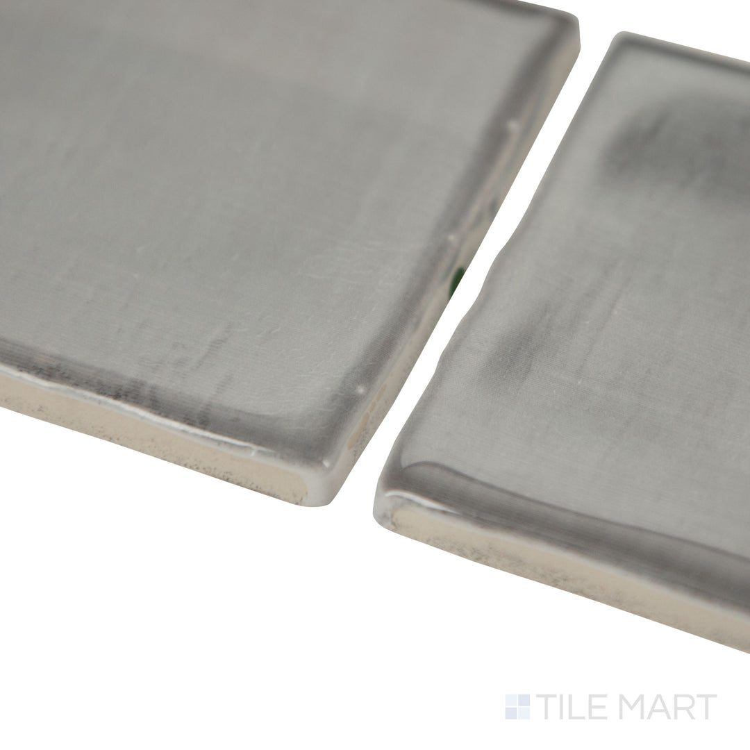 Angled shot of Mesmerist Charm 3x12 glossy glazed ceramic tile, featuring a vibrant hue, reflective glossy finish, and a contemporary rectangular layout.  