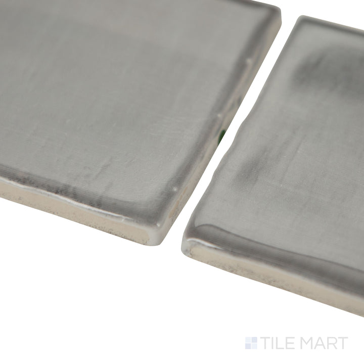 Angled shot of Mesmerist Charm 3x12 glossy glazed ceramic tile, featuring a vibrant hue, reflective glossy finish, and a contemporary rectangular layout.  