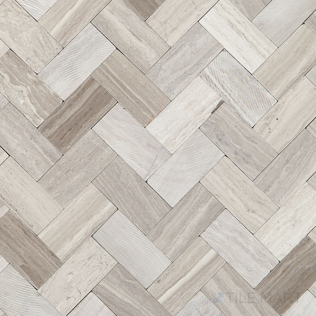 Top-down view of the Minute Mosaix Chenille White Herringbone marble and limestone mosaic, displaying its intricate herringbone layout and natural stone texture.