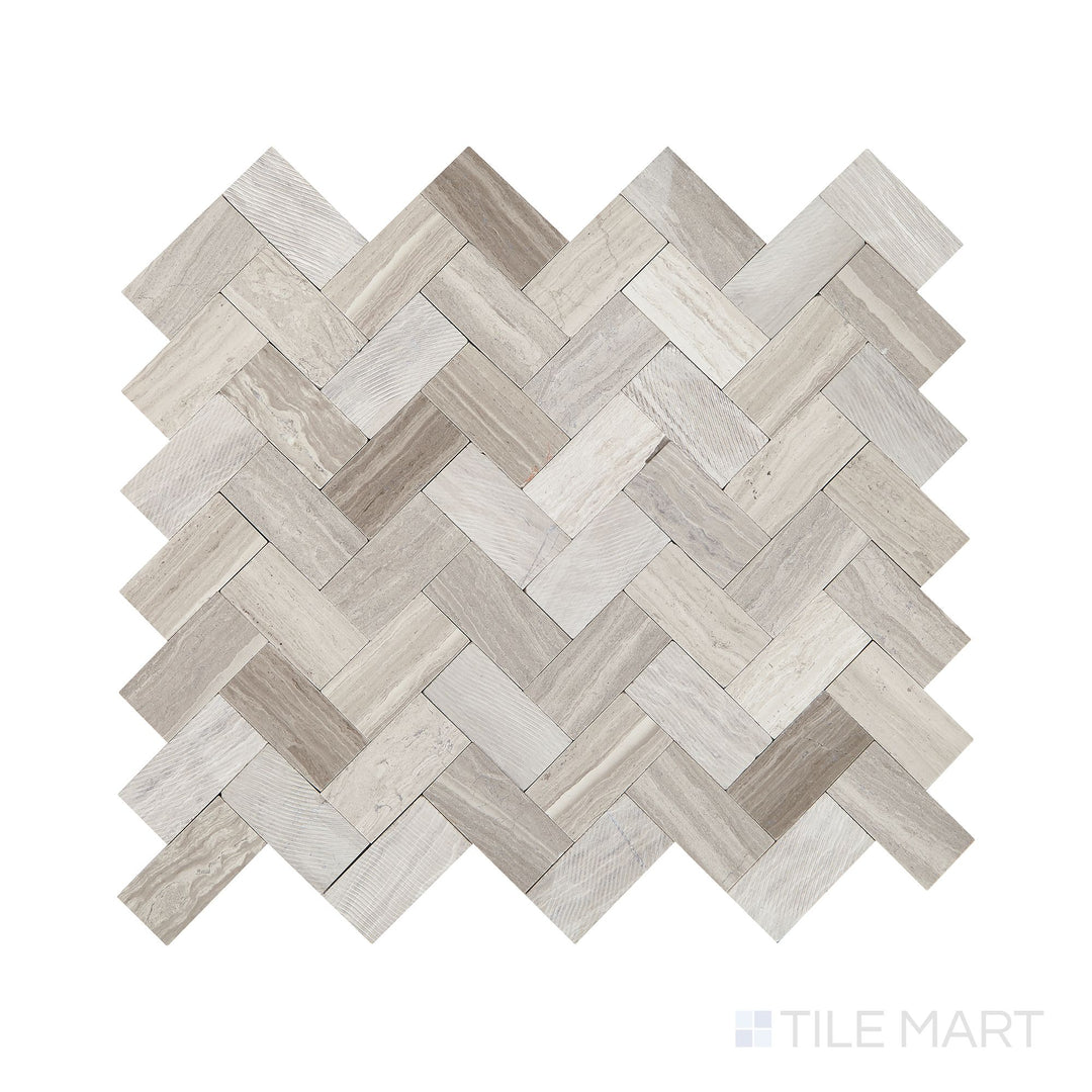 Angled shot of Minute Mosaix Chenille White herringbone marble limestone mosaic, featuring soft white tones, an elegant herringbone pattern, and a refined natural stone texture.  