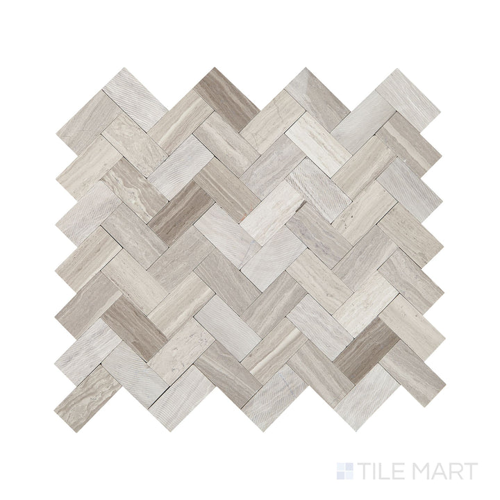Angled shot of Minute Mosaix Chenille White herringbone marble limestone mosaic, featuring soft white tones, an elegant herringbone pattern, and a refined natural stone texture.  