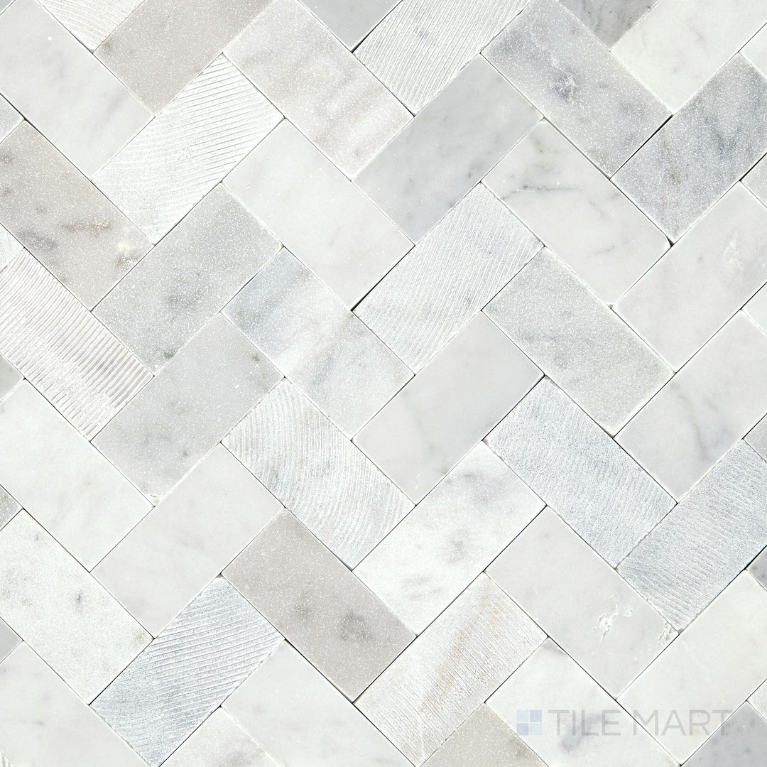 Overhead shot of the Minute Mosaix Carrara White Herringbone marble and limestone mosaic, showcasing its elegant pattern and classic Carrara veining.