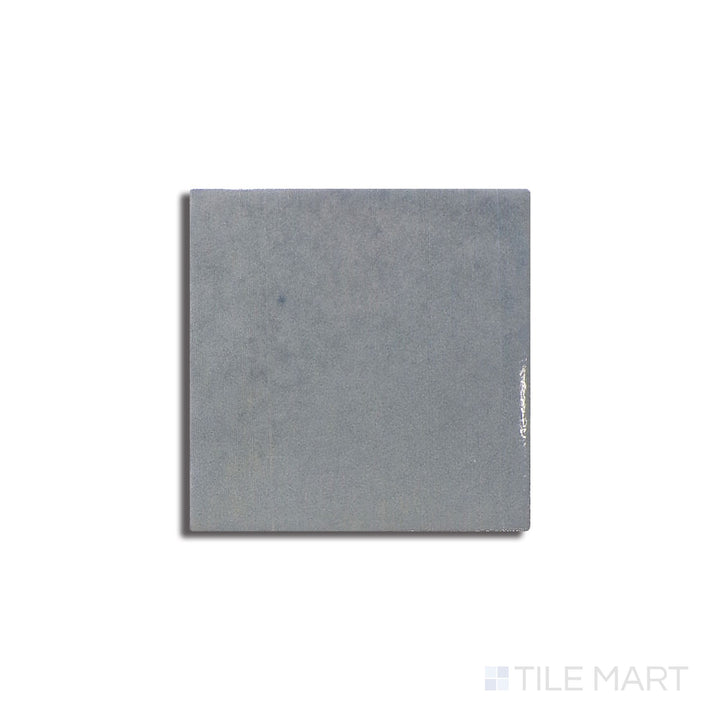 Diagonal view of Zellige Neo Cielo 4x4 glossy glazed ceramic tile, showcasing a soft sky-blue tone, a glossy sheen, and a slightly irregular surface for an artisanal look.  