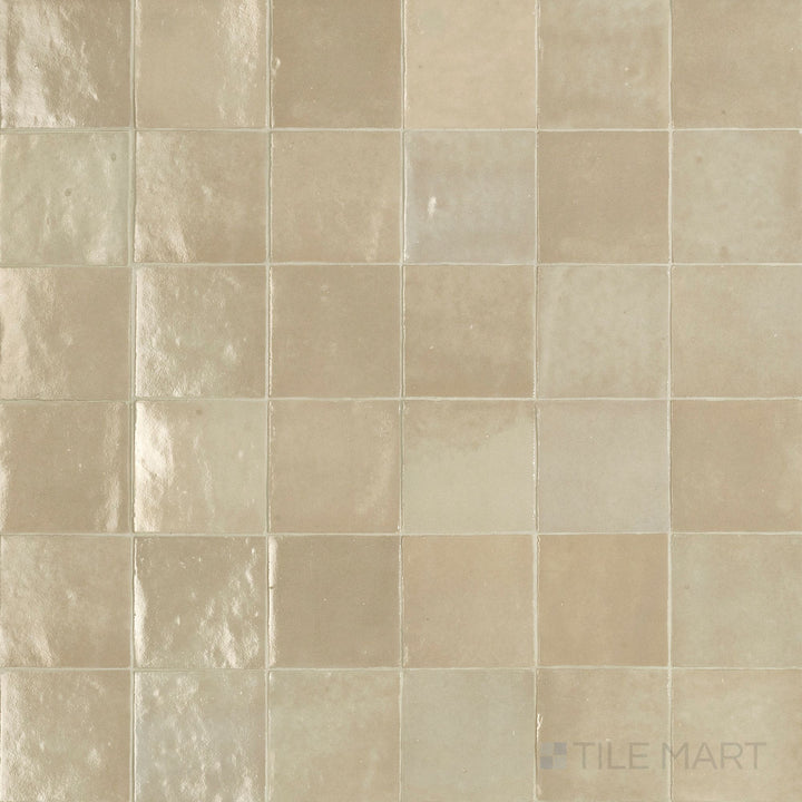 Flat-lay image of Zellige Neo Lana 4X4 Glossy Glazed Ceramic, highlighting its warm neutral color and smooth glossy glaze.