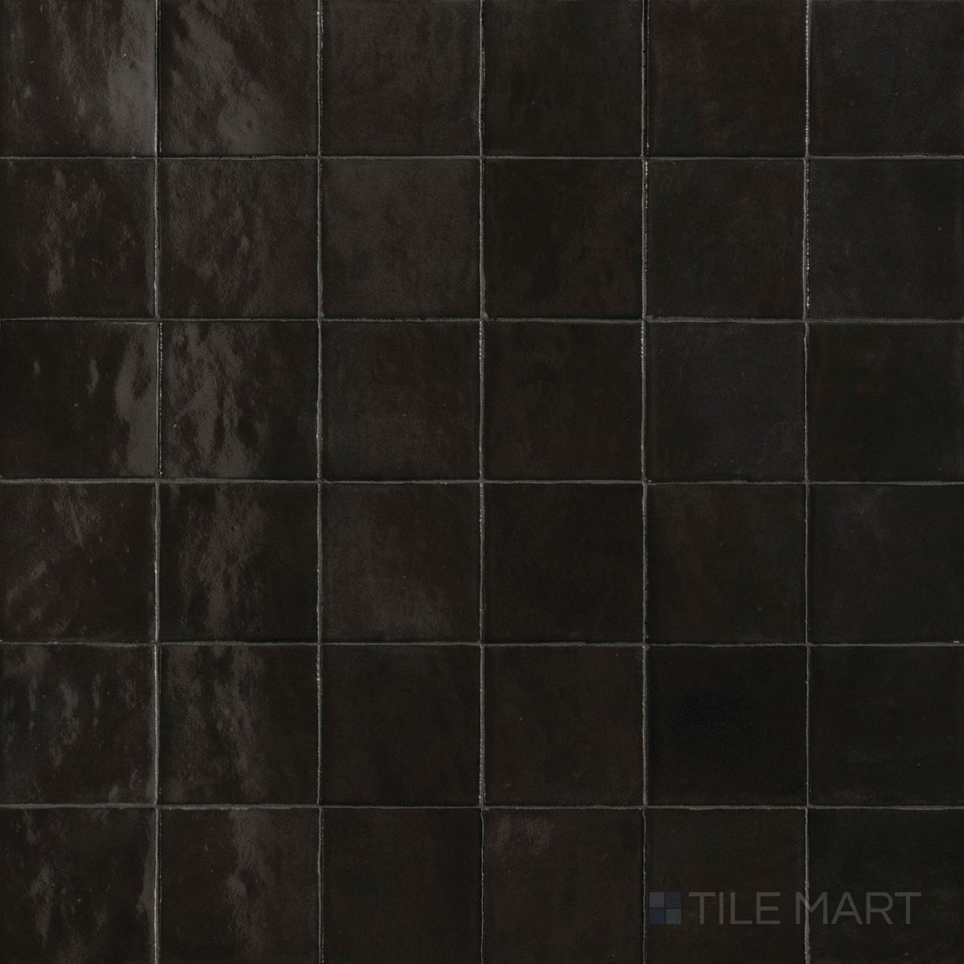 Top-down view of Zellige Neo Carbone 4x4 glossy glazed ceramic tile, showcasing deep tone and handcrafted surface variation.