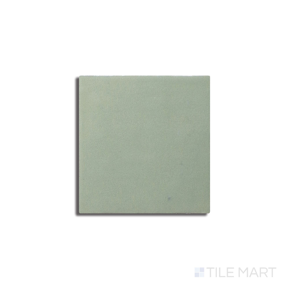 Angled shot of Zellige Neo Turchese 4x4 glossy glazed ceramic tile, featuring a deep turquoise shade, an elegant glossy surface, and a handcrafted appeal.  