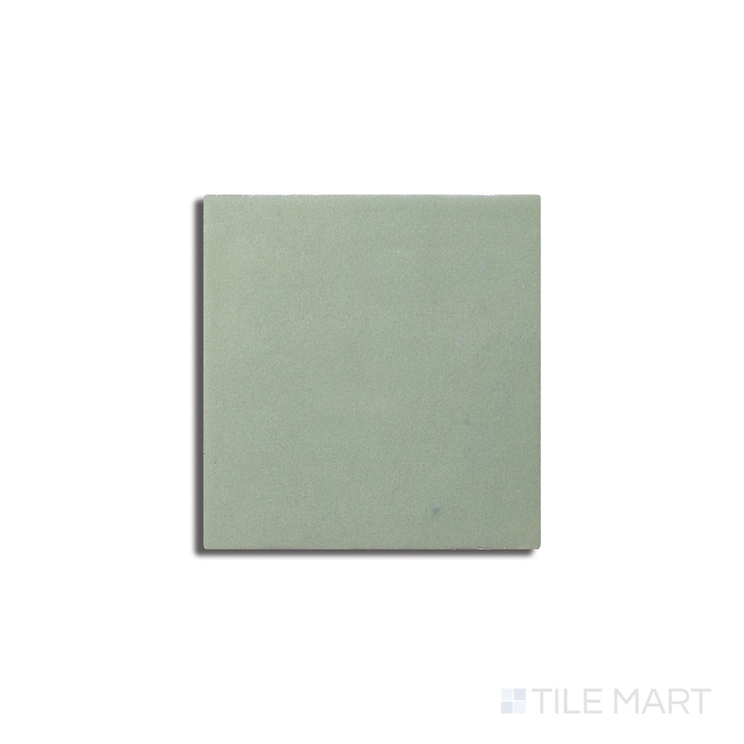 Angled shot of Zellige Neo Turchese 4x4 glossy glazed ceramic tile, featuring a deep turquoise shade, an elegant glossy surface, and a handcrafted appeal.  