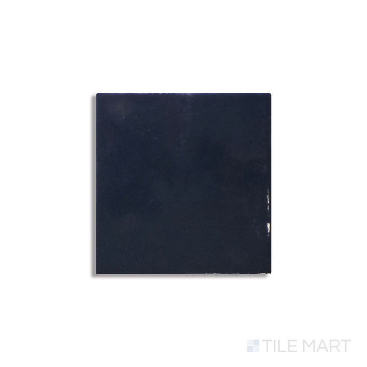 Slanted perspective of Zellige Neo China 4x4 glossy glazed ceramic tile, emphasizing its warm terracotta tone, high-gloss texture, and a slightly rustic, handcrafted feel.  