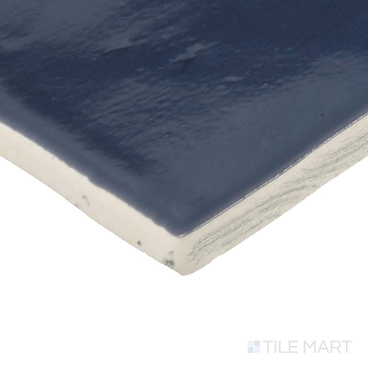 Angled close-up of Zellige Neo China 4X4 Glossy Glazed Ceramic Tile, showcasing its striking red tones with a smooth, high-gloss surface.