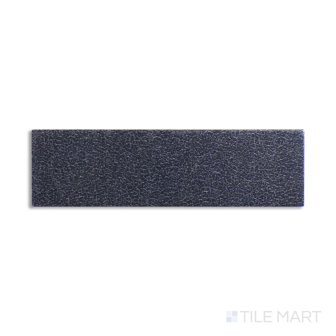 Angled shot of Inyo Indigo 2x8 satin glazed ceramic tile, featuring a deep indigo blue shade, smooth satin finish, and a clean rectangular profile.  