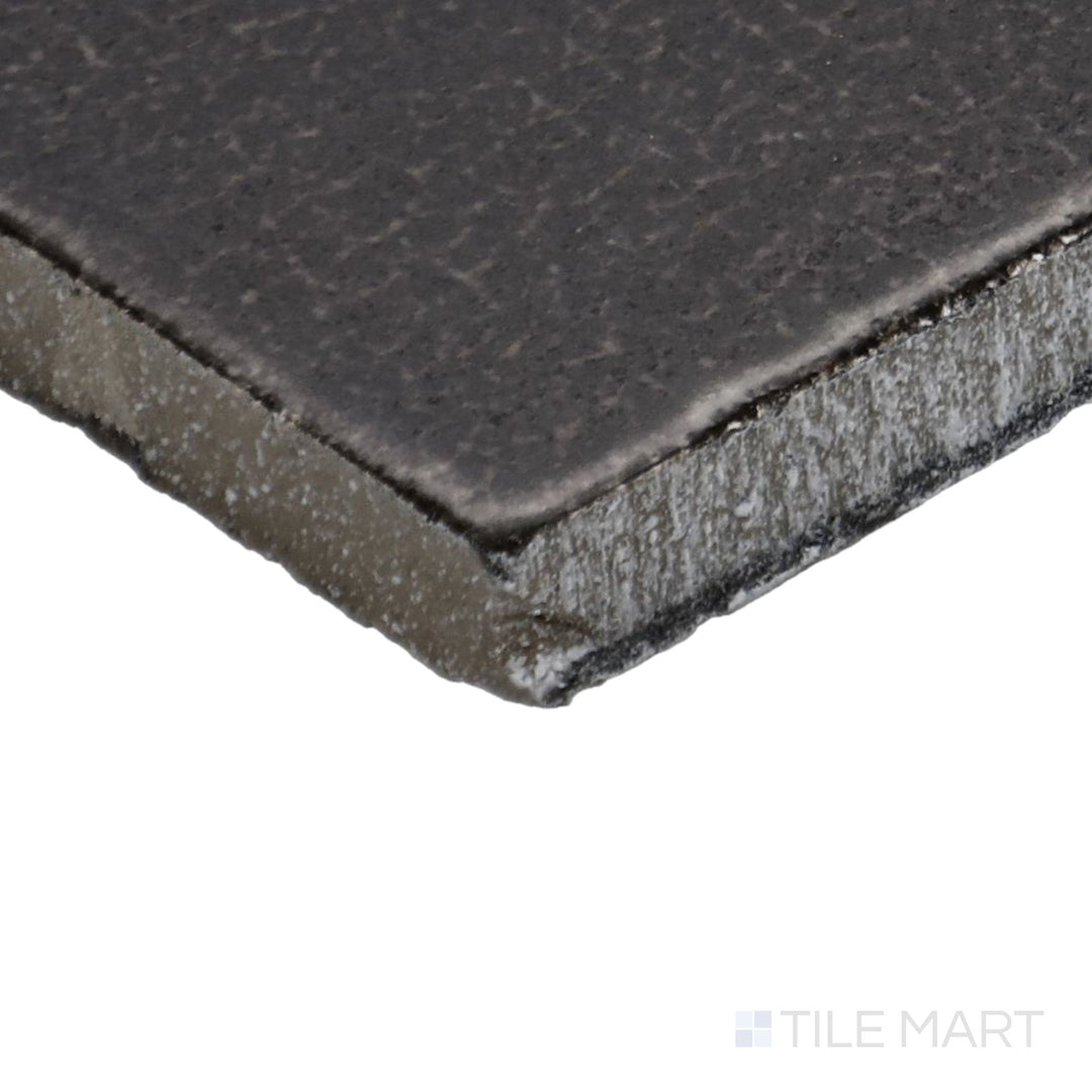 Side perspective of Inyo Ink 2X8 Satin Glazed Ceramic Tile, capturing its rich charcoal-black tones with a muted satin glaze.