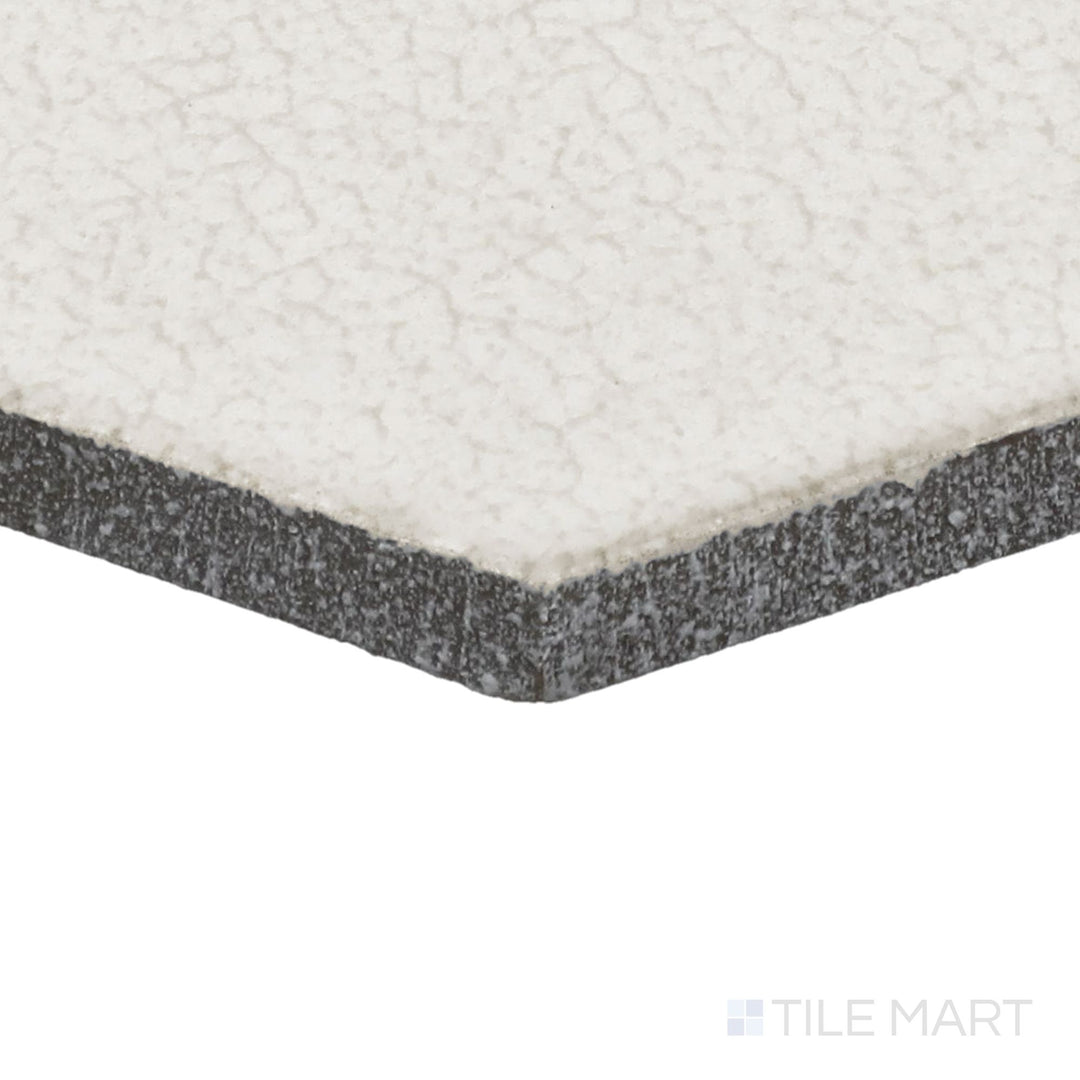 Angled close-up of Inyo Crema 8" Hex Satin Glazed Ceramic Tile, showcasing its soft neutral hues in a stylish hexagonal shape.