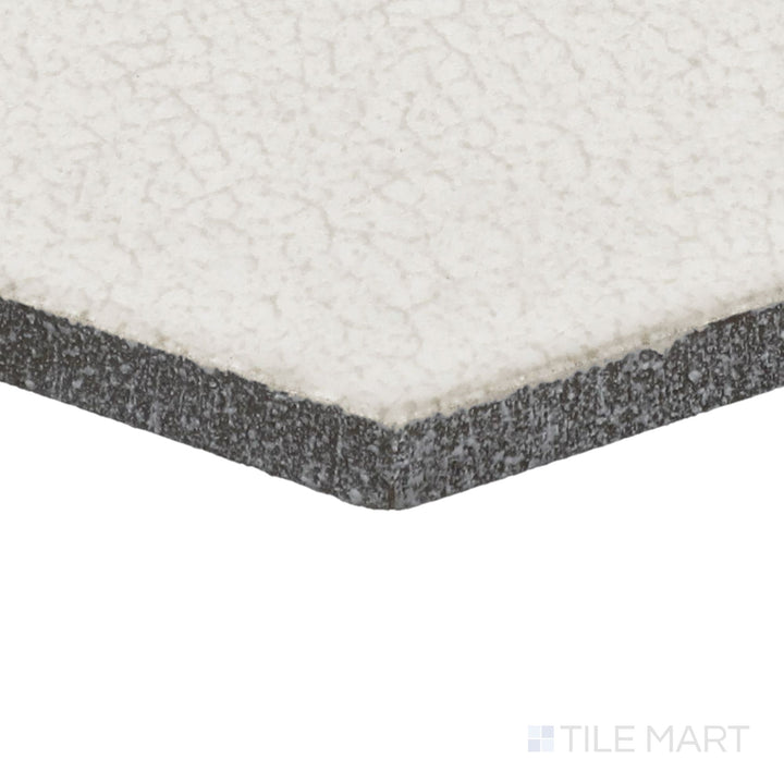 Angled close-up of Inyo Crema 8" Hex Satin Glazed Ceramic Tile, showcasing its soft neutral hues in a stylish hexagonal shape.