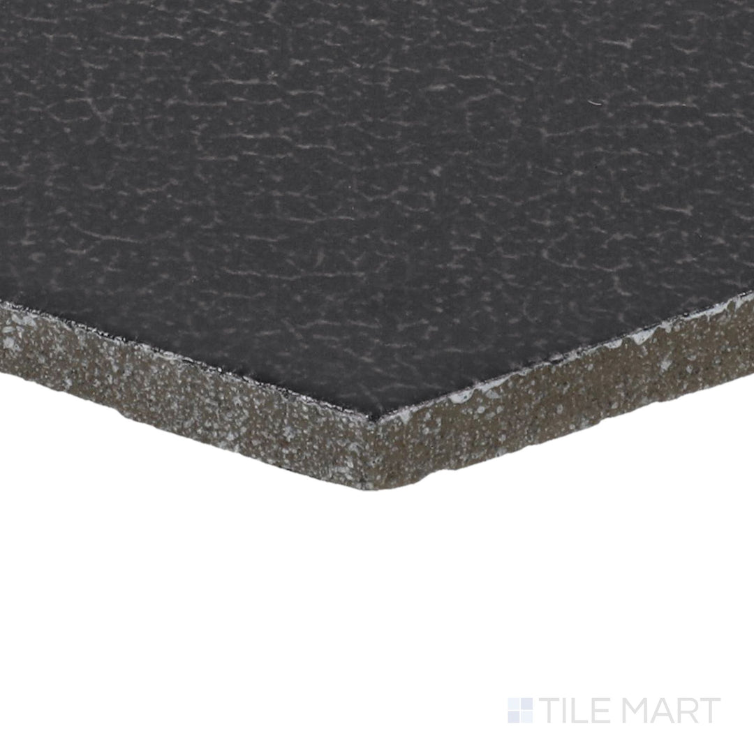 Side perspective of Inyo Ink 8" Hex Satin Glazed Ceramic Tile, capturing its deep ink-black color in a striking hexagonal pattern.