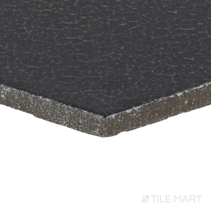 Side perspective of Inyo Ink 8" Hex Satin Glazed Ceramic Tile, capturing its deep ink-black color in a striking hexagonal pattern.