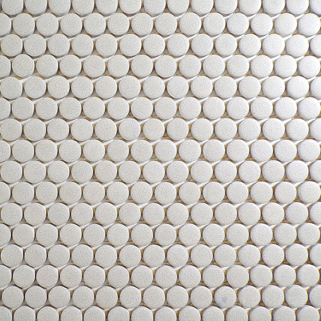 Flat-lay image of Inyo Crema Penny Round Matte Glazed Ceramic Mosaic, highlighting its classic penny round shape with a soft neutral tone.
