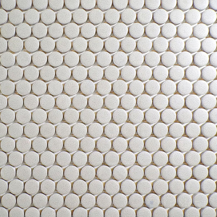Flat-lay image of Inyo Crema Penny Round Matte Glazed Ceramic Mosaic, highlighting its classic penny round shape with a soft neutral tone.