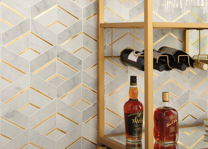 Featured in a room setting, the Lavaliere Alluring White and brass intermix honed marble mosaic adds contrast and refined metallic detail
